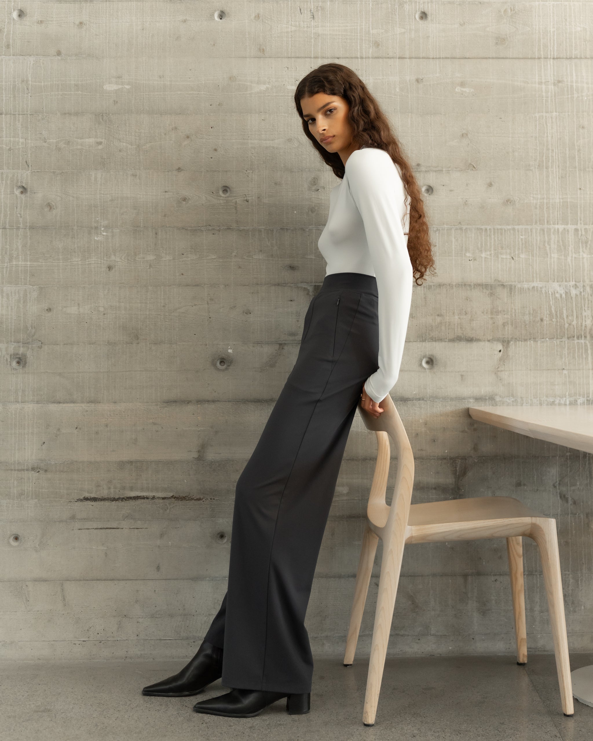 Woman wearing Ninepine Asana Relaxed Straight Pants styled with a fitted long sleeve top, comfortable work pants for women.